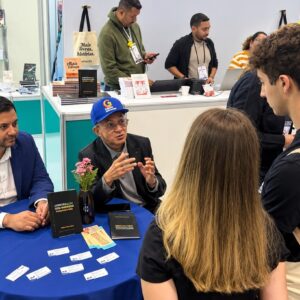 Professor Bibiano Costa de boné azul durante autógrafos na Bienal.